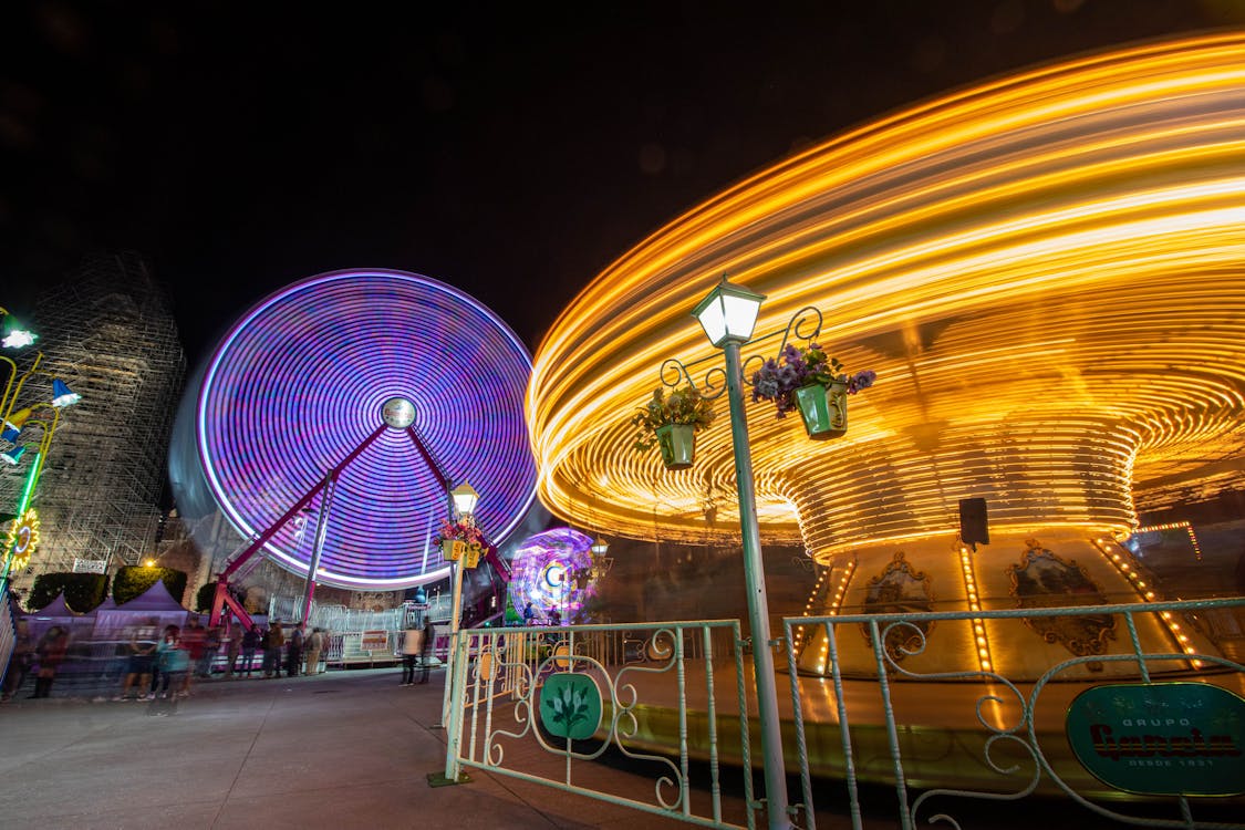Illuminated Carousel and Ferris Wheel at Night