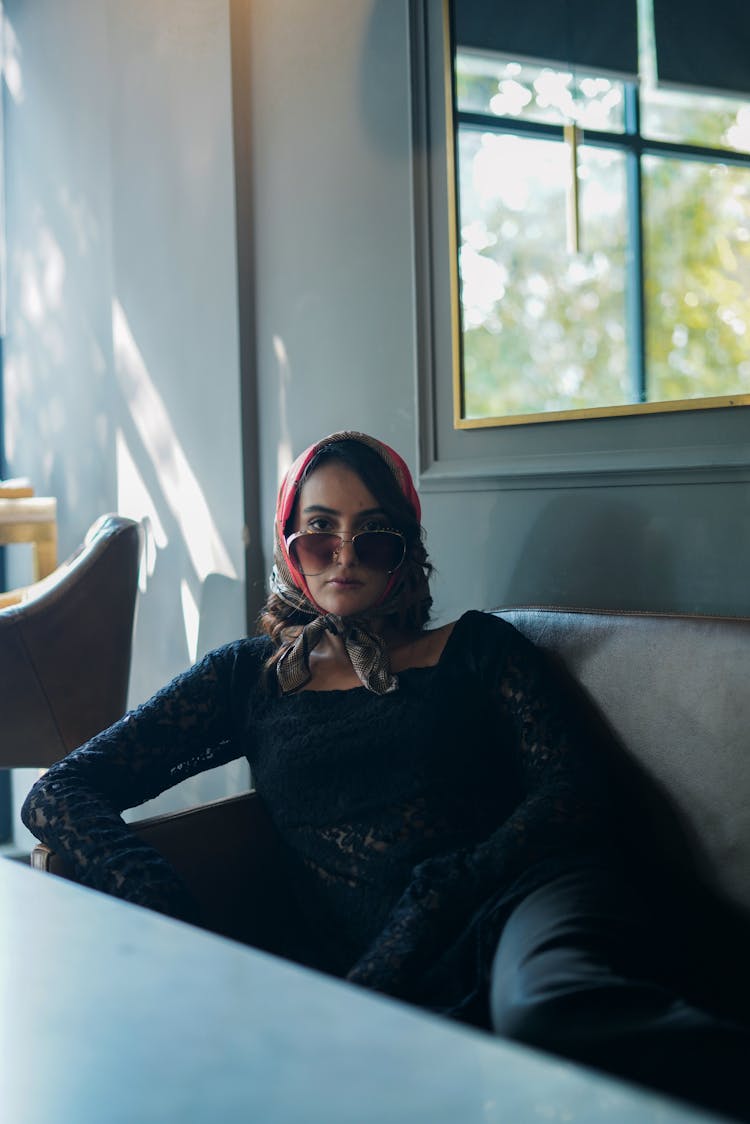 Woman In Head Scarf Sitting On Couch