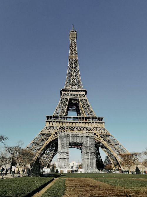 Free Iconic Eiffel Tower under a clear blue sky in Paris, a must-see tourist landmark. Stock Photo