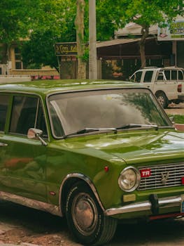 A vibrant green vintage car parked on a street, showcasing a classic automotive design.