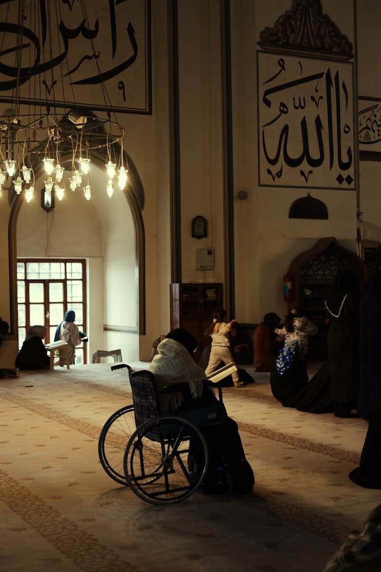 A Person In A Wheelchair In A Mosque