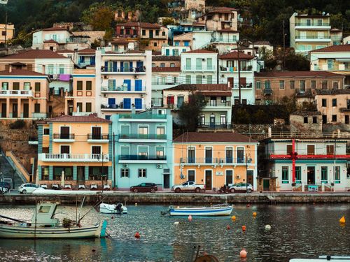Free Charming colorful buildings along a tranquil waterfront with boats docked, reflecting town life. Stock Photo