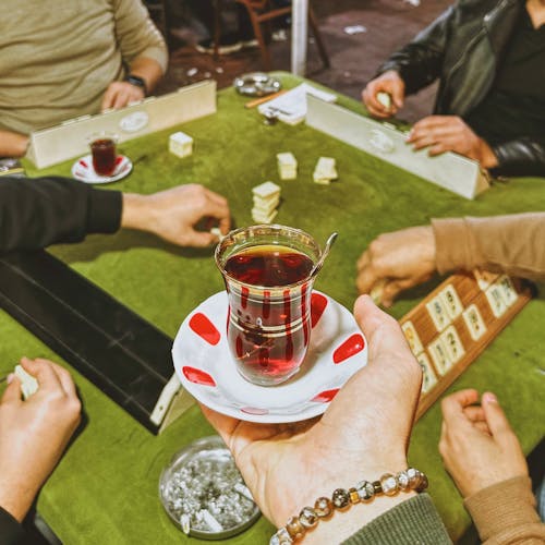 People Drinking Tea and Playing a Board Game 