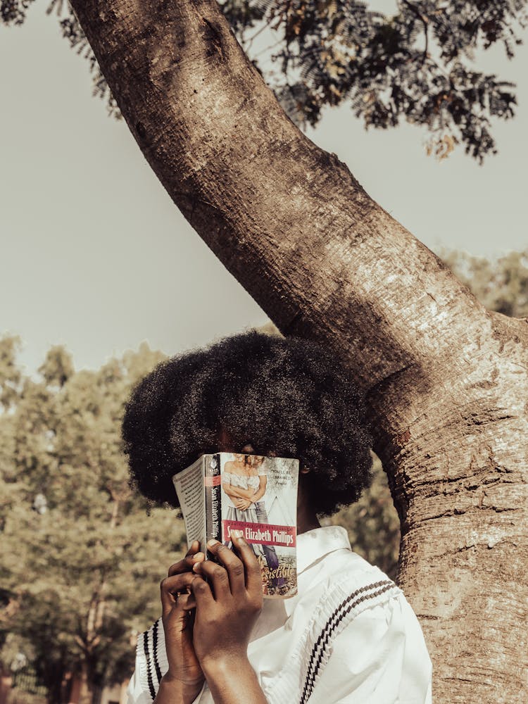 Woman Covering Face With Book