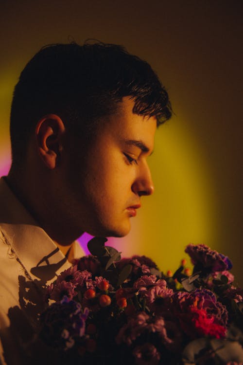 Close-Up Photo of a Young Man Holding a Flower Bouquet