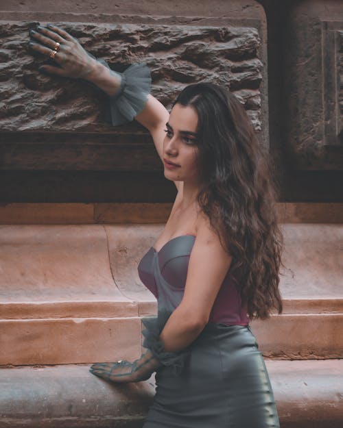 Beautiful Woman in an Evening Dress Leaning against a Building 