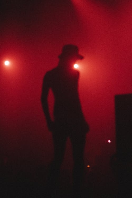Silhouette of a Man in Hat at a Rock Concert 