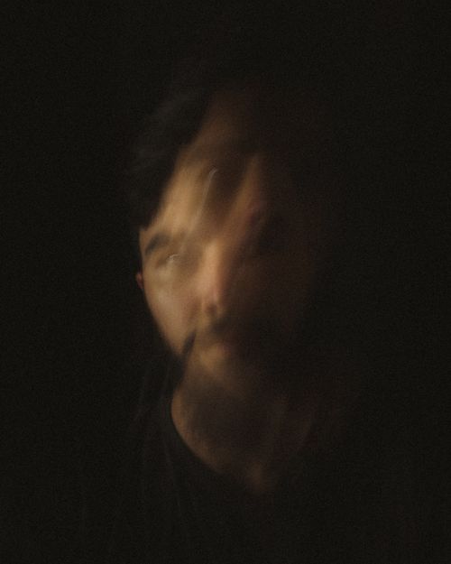 Free Abstract blurred portrait of a bearded man with black background, creating a mysterious and artistic effect. Stock Photo