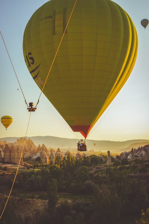 Yellow Hot Air Balloon Flying over Cappadocia at Sunset