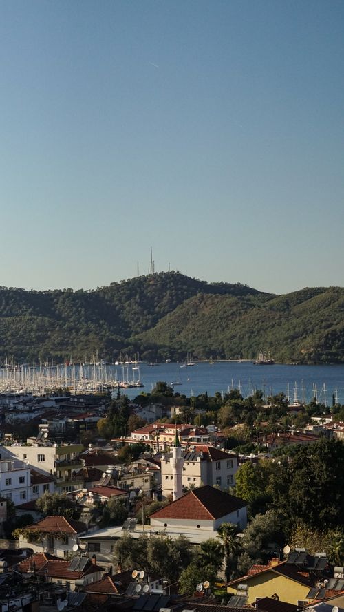 Free Aerial photo showcasing Fethiye harbor, buildings, and lush hills on a clear day in Türkiye. Stock Photo