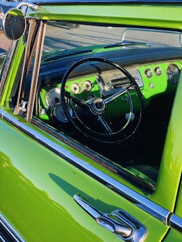 Detailed view of a classic green car interior showcasing the dashboard and steering wheel.