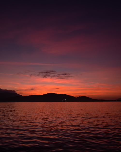 Free A breathtaking seascape with a vibrant sunset sky reflecting on the ocean. Stock Photo