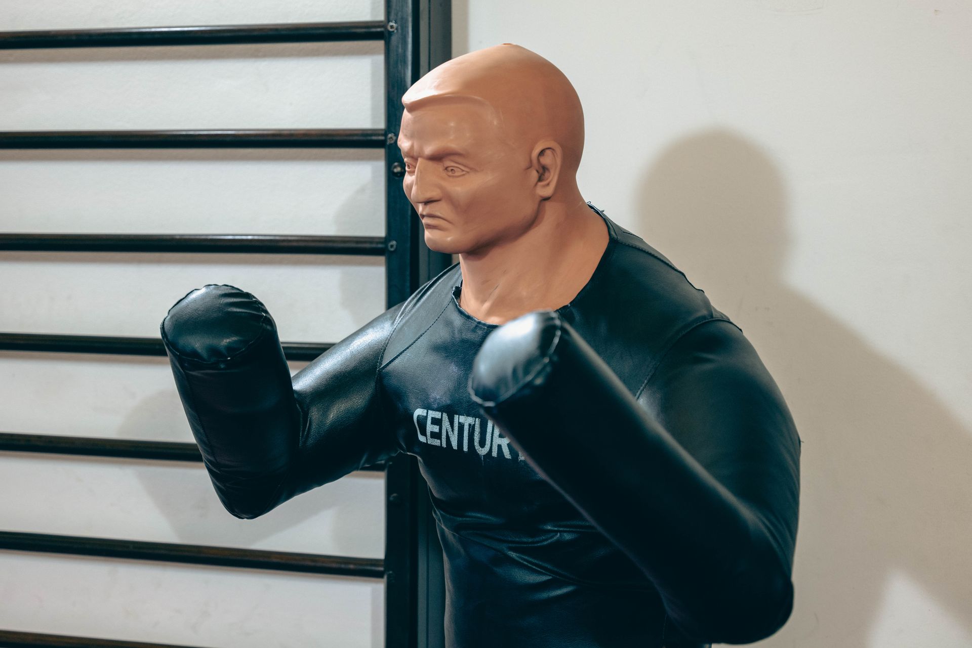 A traditional wooden Wing Chun practice dummy in a simple training hall