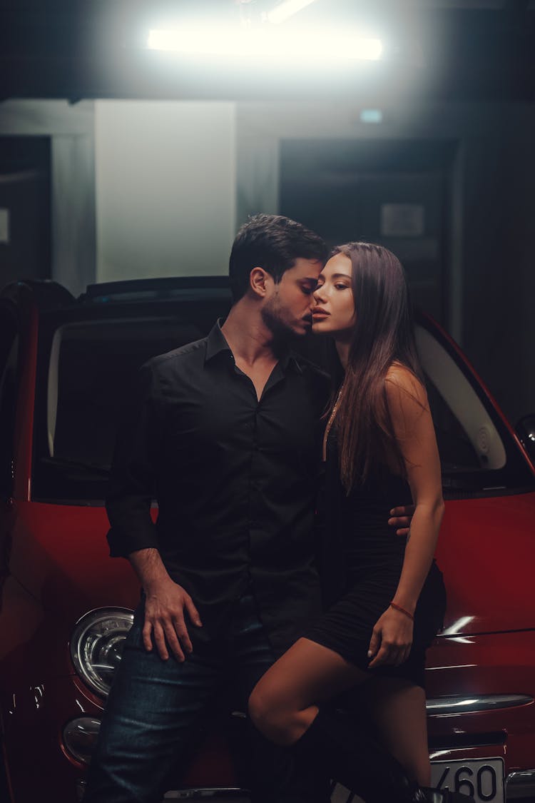 Couple Embracing By A Car