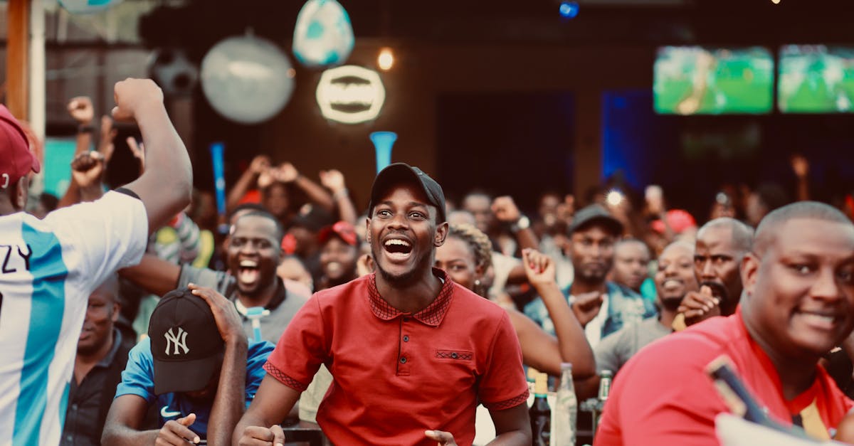 A lively group of fans enthusiastically cheering at a sports bar during a live match.