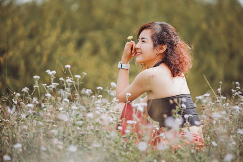 Smiling Woman Sitting on a Field 