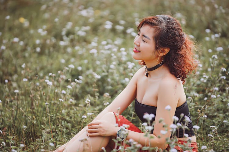 Woman Sitting Among Flowers