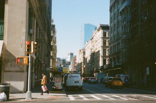 Free Busy urban street in New York City with people, vehicles, and skyscrapers under a clear sky. Stock Photo