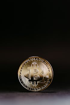 A detailed image of a shining Bitcoin coin on a dark, black background symbolizing cryptocurrency.