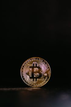 Shiny Bitcoin coin with a black background, symbolizing cryptocurrency's digital value.