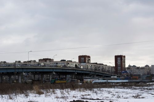 Free A cityscape with apartment buildings and bridge in a snowy winter setting. Stock Photo
