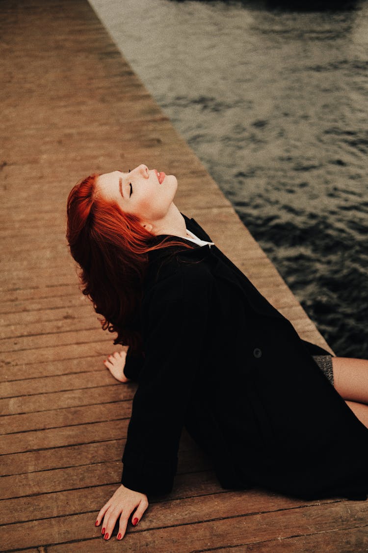 A Woman Sitting On A Pier