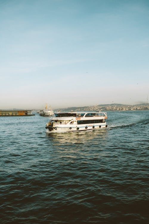 White and Black Boat on Water under Blue Sky