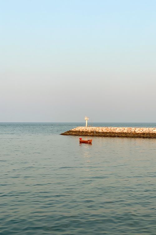 Free Calm ocean scene in Thailand with a pier and small boat under a clear sky. Stock Photo