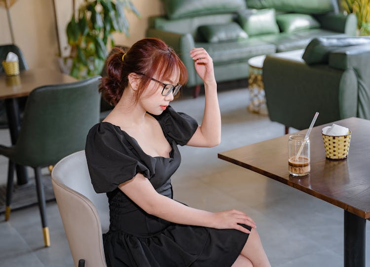 Photograph Of A Girl In A Black Dress Sitting