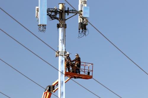 Two Workers Beside a Telephone Pole