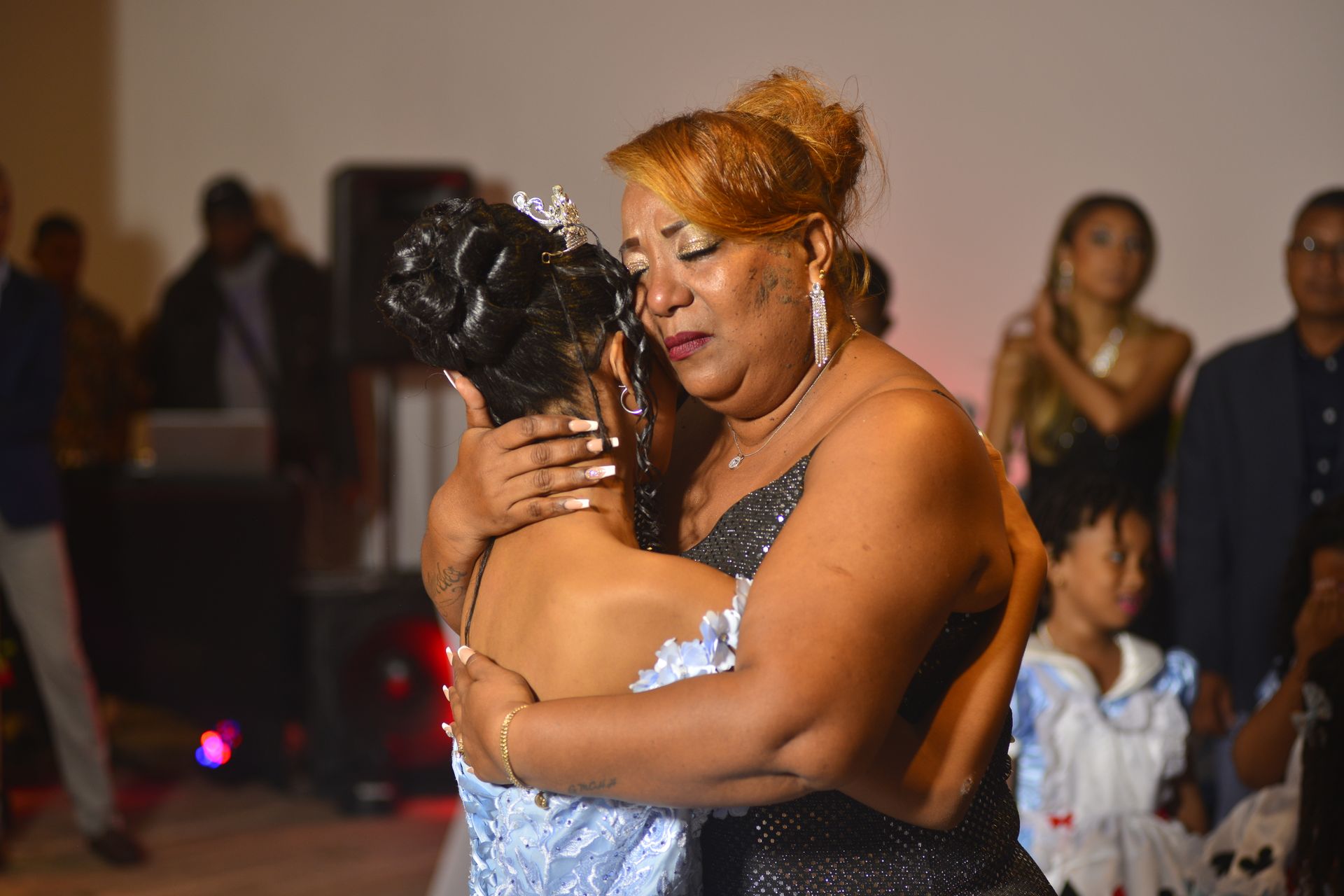 Heartfelt moment of mother and daughter embracing during a celebration.