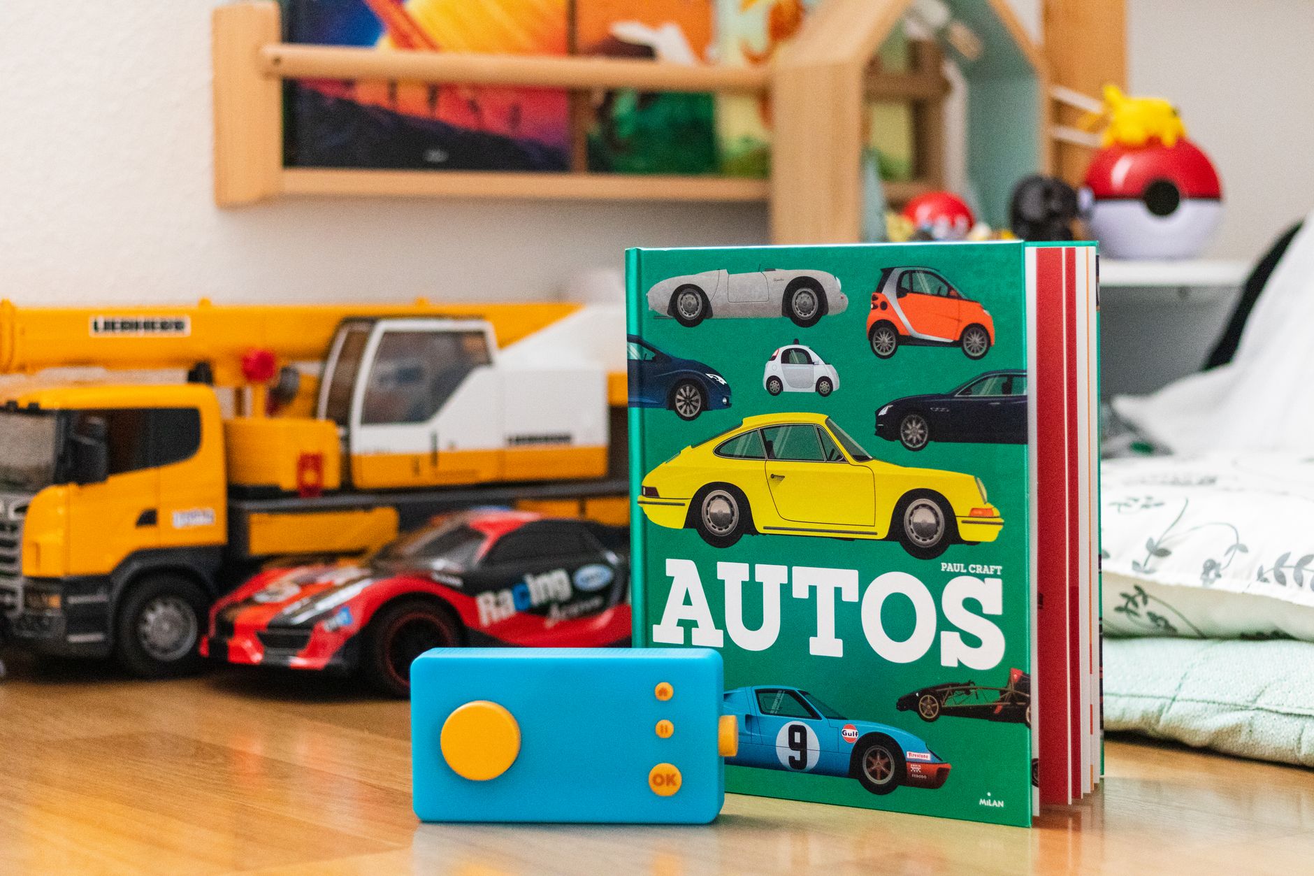 Vibrant display of children's auto book and toy cars set on a wooden surface.