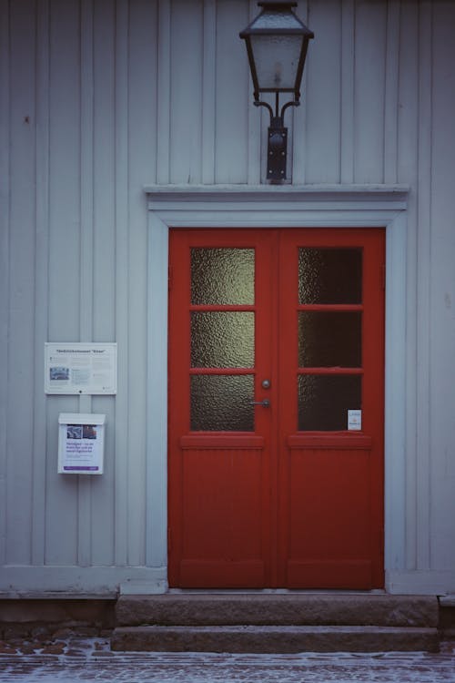 Základová fotografie zdarma na téma betonová stěna, červené dveře, dveřní lampa