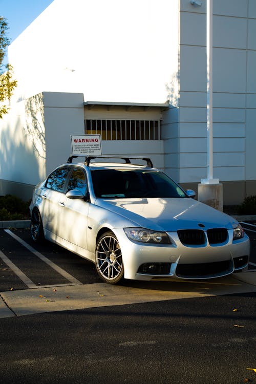 Photo of a Silver Car Parked Near a White Building