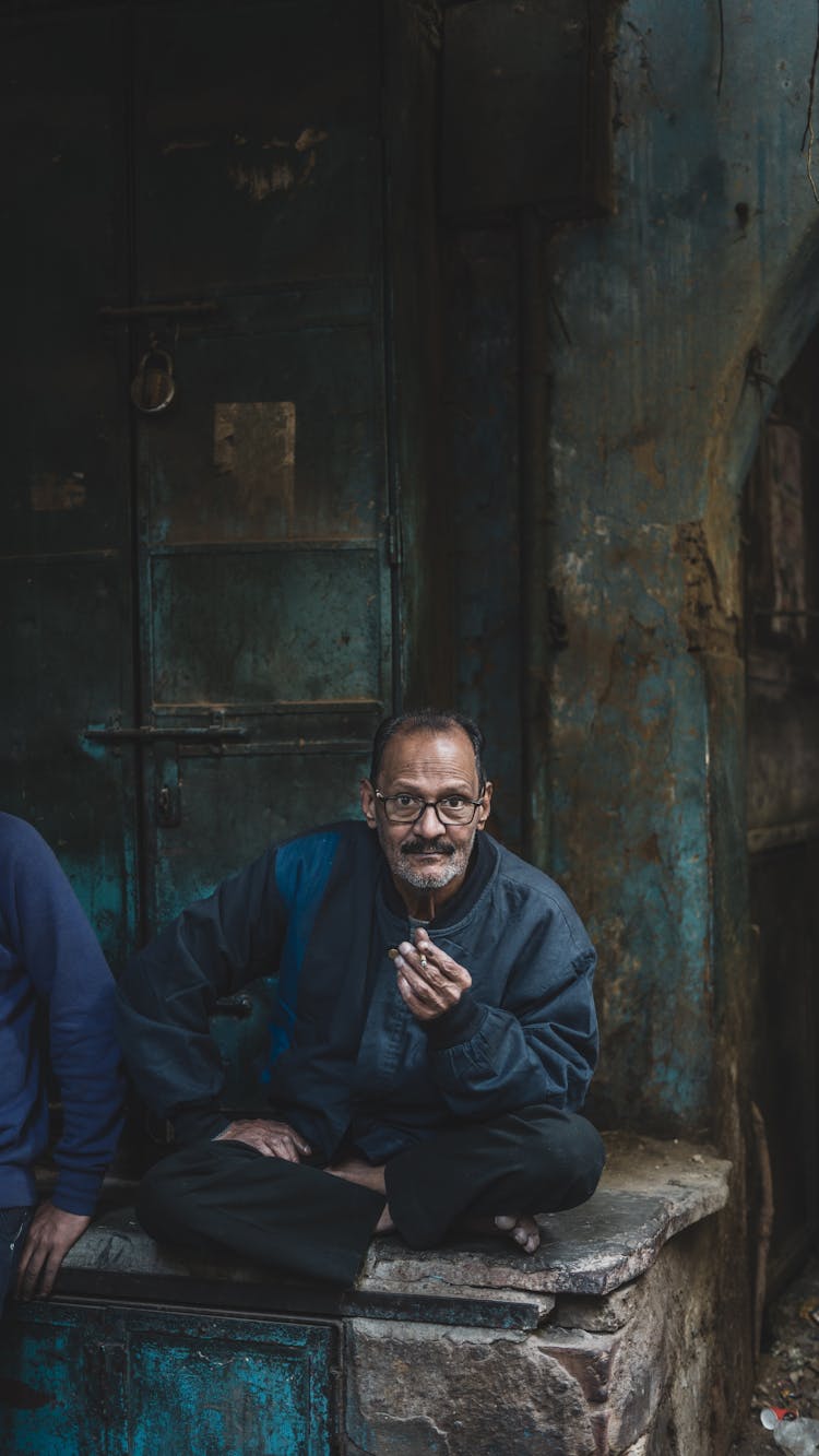 Old Man Sitting Outdoors Smoking Cigarette