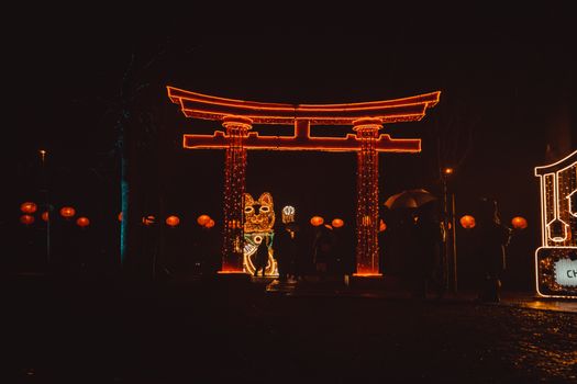 Magical night scene with an illuminated Torii gate and festive lanterns celebrating a cultural festival.