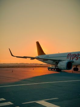 A scenic view of a commercial airplane on the runway at sunset, captured at Kırklar Airport.