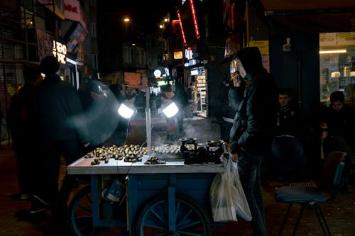 Man Selling Chestnuts on Night City Street
