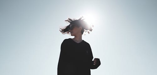 Sunlight over Woman in Black Clothes