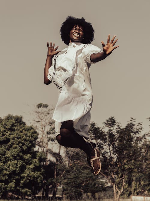 Free Woman in White Dress Jumping Stock Photo