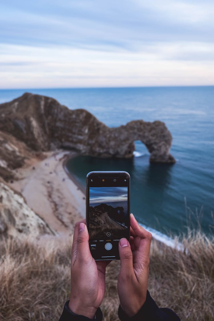 Photo Of Person Taking Picture Of Seashore