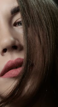 Close-up portrait of a woman with long brown hair and red lipstick.