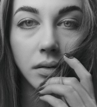 Black and white close-up portrait of a woman's face with a serene expression.