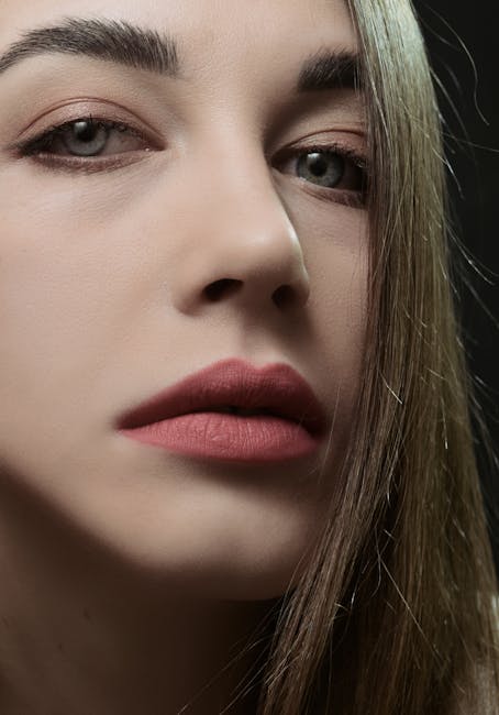 Elegant close-up portrait of a woman with striking red lips and soft expression.