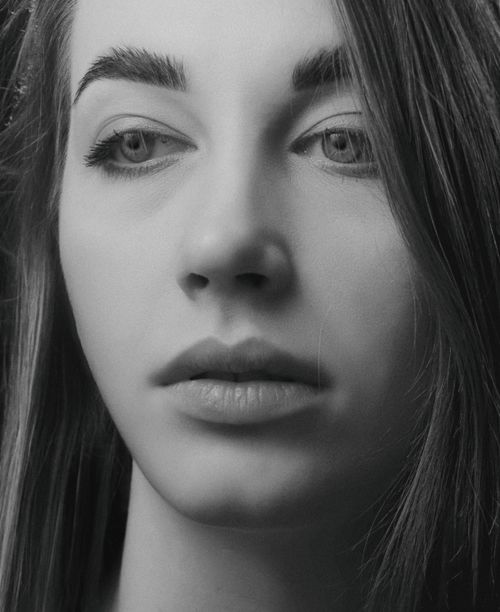 Free Close-up black and white portrait of a woman with a thoughtful expression. Stock Photo