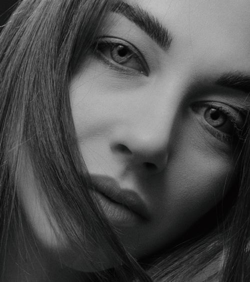 Free Close-up black and white portrait showcasing a woman's serene expression and captivating gaze. Stock Photo