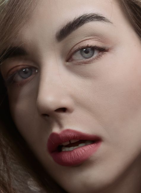 Elegant close-up portrait of a woman with expressive gray eyes and natural makeup.