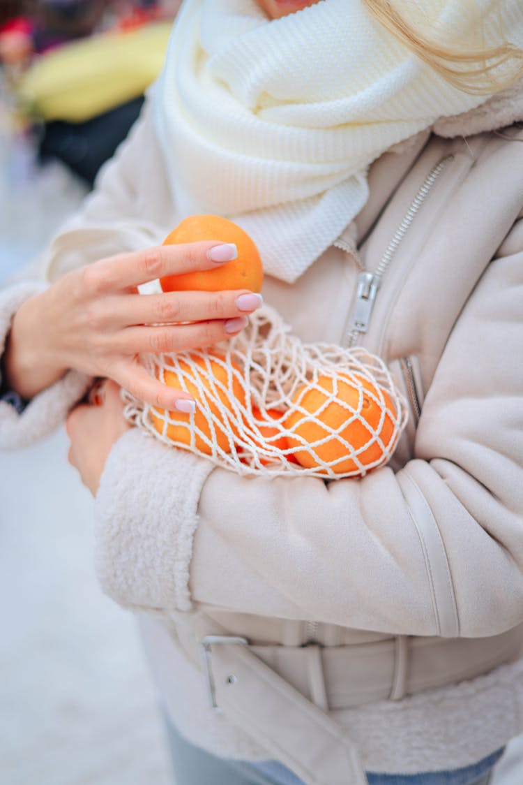 Woman Holding Oranges In A Bag 