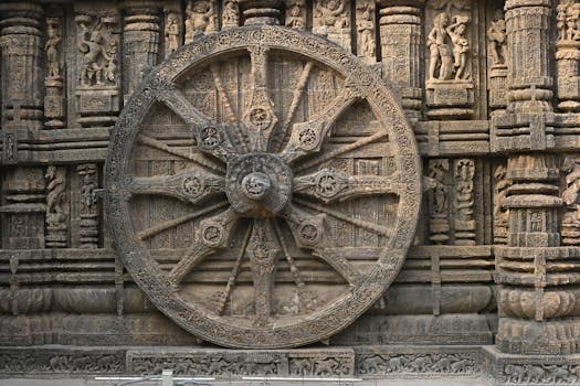 Detailed stone carving of a wheel on Konark Sun Temple, showcasing ancient Hindu architecture.