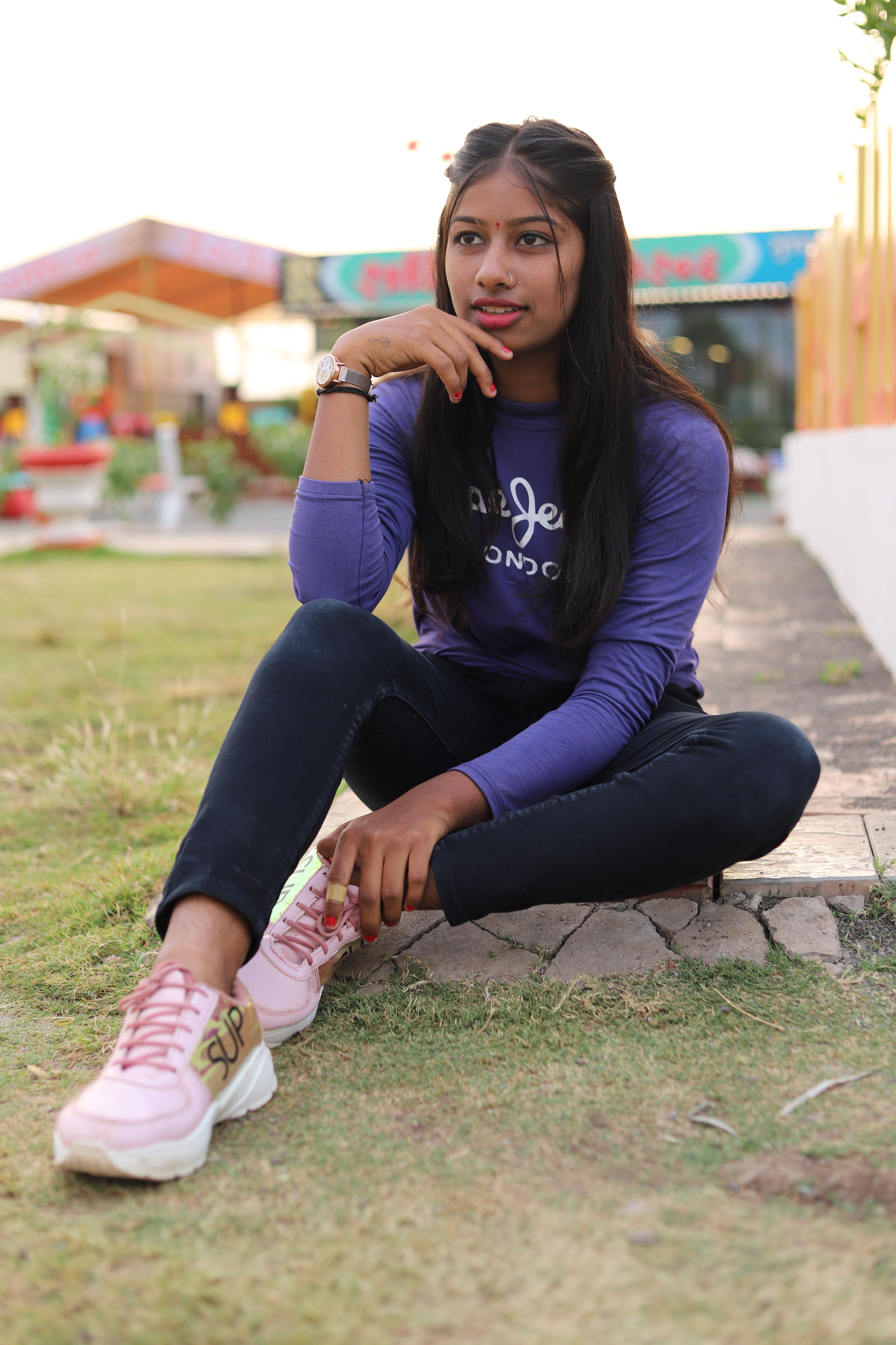Portrait of a young woman sitting outdoors in Dhari, Gujarat, India.